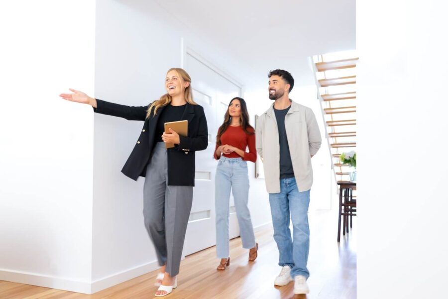 Real estate agent showing a young couple a new house. The house is modern and contemporary.