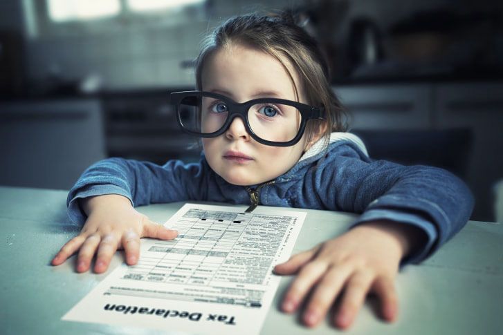 Close up of young girl sitting with tax declaration at table
