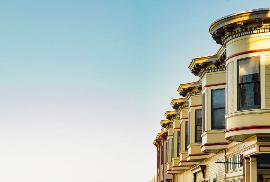 San Francisco residential house architecture with clear blue sky, featuring the upper floors of a row of Victorian houses