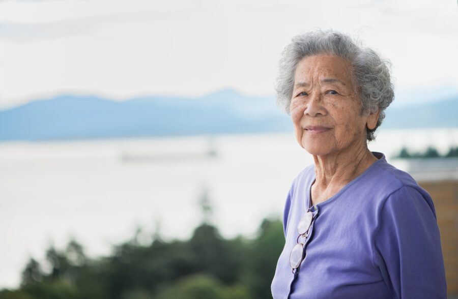 Elderly woman looking out over the water and mountains