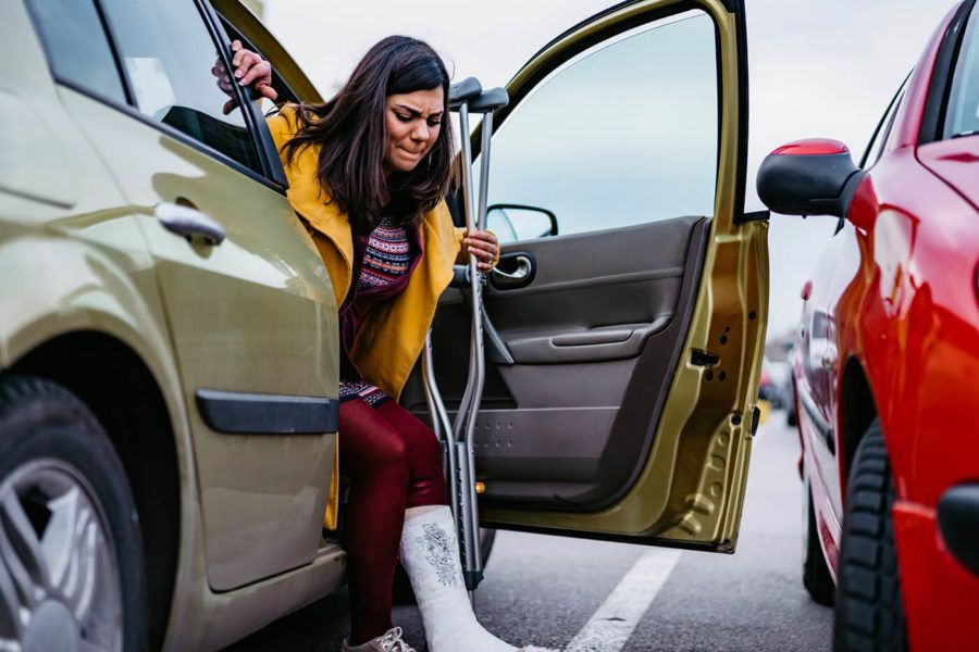 Woman with cast getting out of car