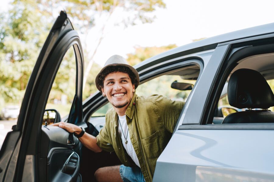 Young man traveling by car getting out of the car