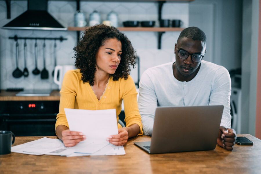 Shot of young couple using a laptop to research high yield savings account rates.