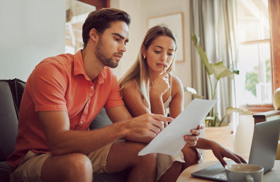 Couple sitting on couch working on getting out of debt