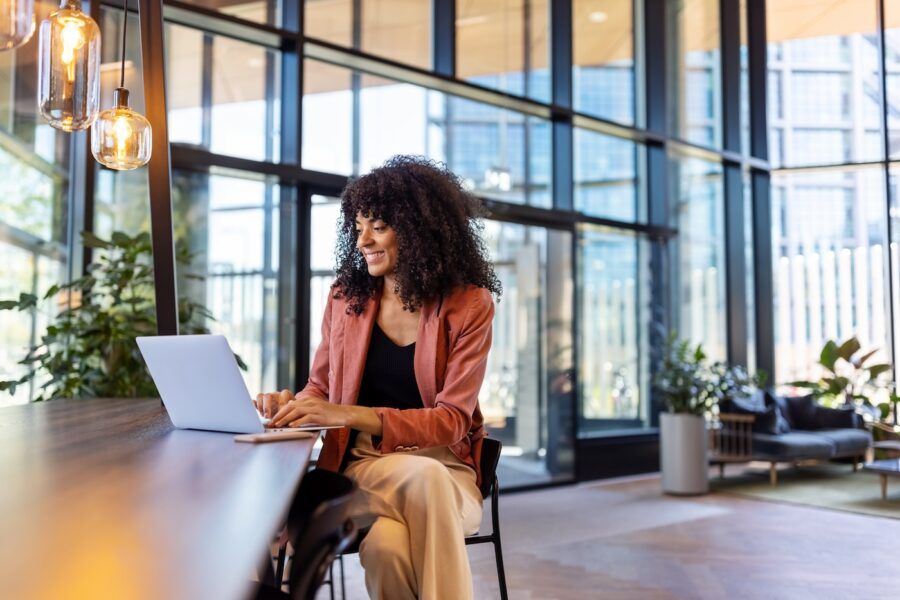 Young woman working on laptop at office cafe.