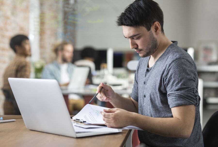 A man working on a laptop at the office.