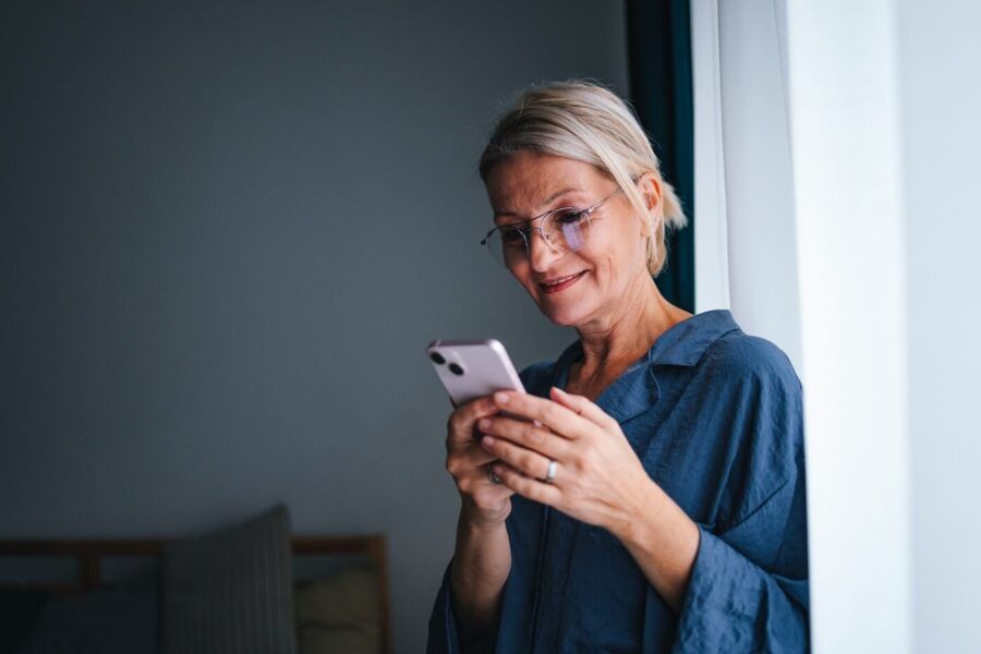 Smiling senior woman checking her smartphone