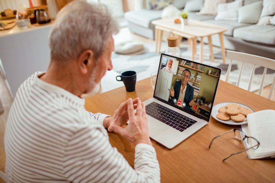 Close up of a senior man talking to his stockbroker over a video call