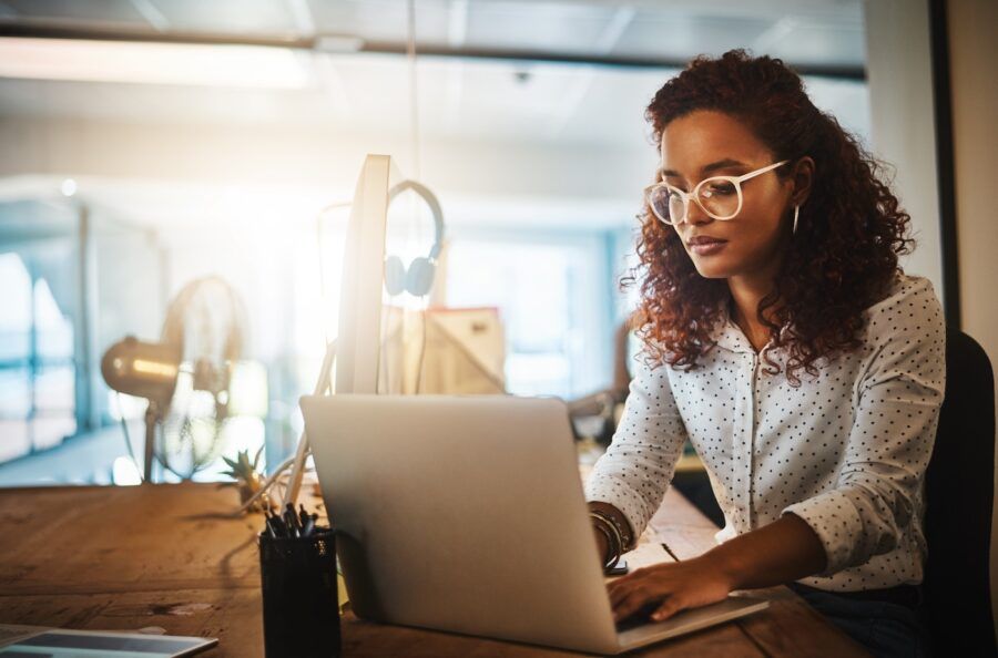 Shot of a young businesswoman using a laptop during a late night at work