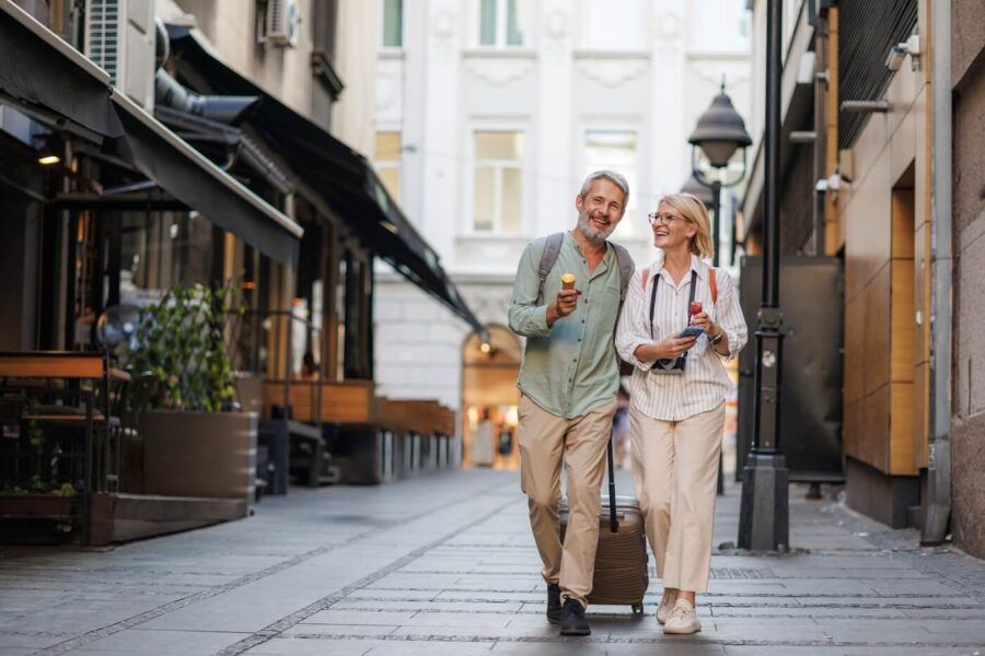 Mature couple enjoying gelato while strolling through a historic downtown area on their vacation