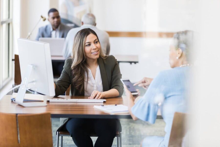 Female bank agent talking to a customer at her desk