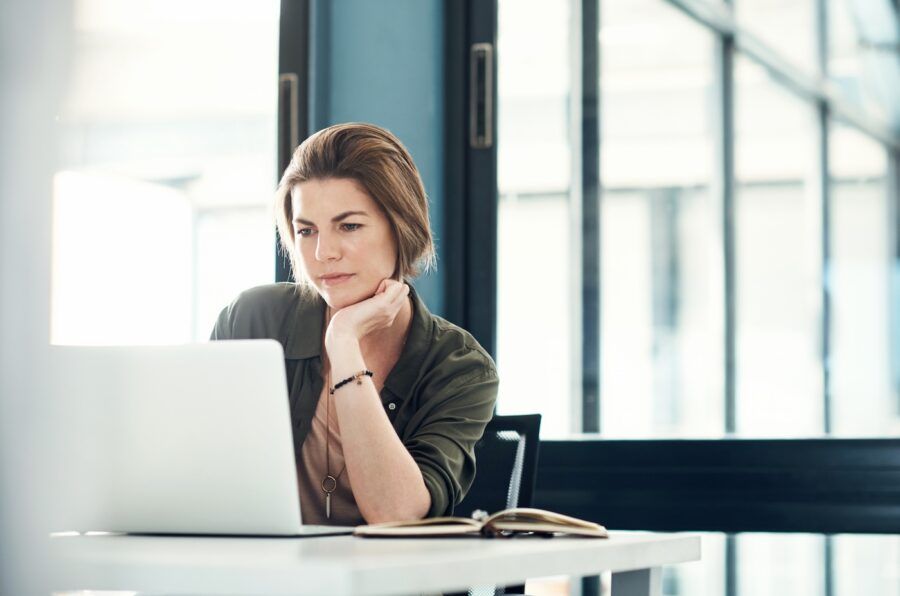 Shot of a young businesswoman using a laptop at her desk in a modern office