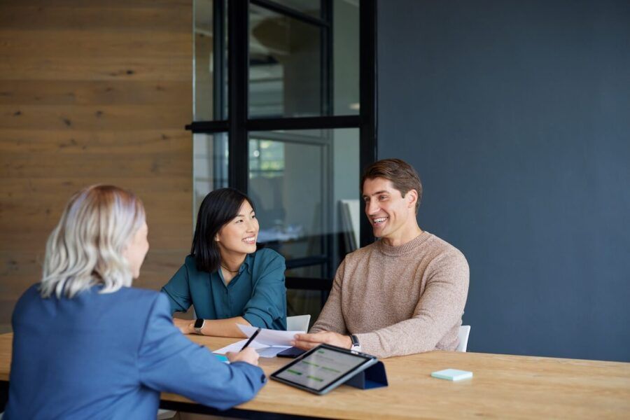 Smiling couple talking to a investment advisor in her office