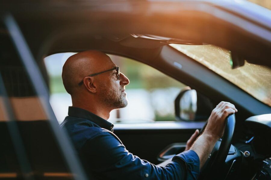Mature man driving a car in the sunset
